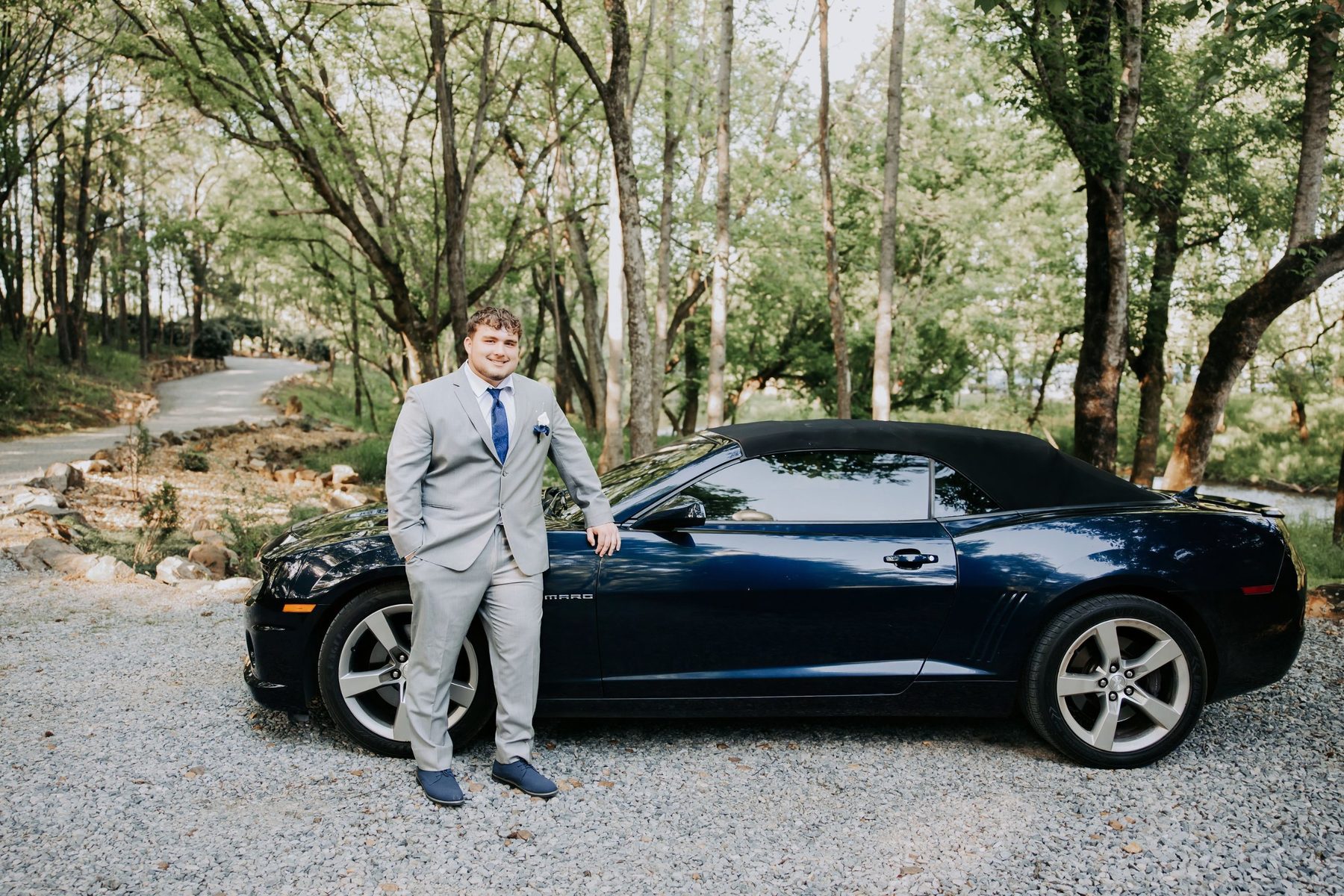 David Haynes standing beside his midnight blue 2011 Camaro SS convertible